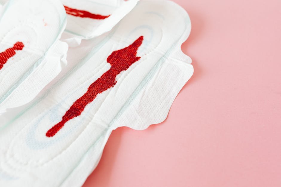 Close-up of stained menstrual pads on a pink surface highlighting women's health and menstruation.