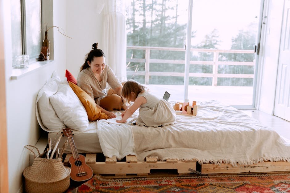 A mother and daughter enjoying quality time in a cozy, light-filled bedroom with toys and a guitar.