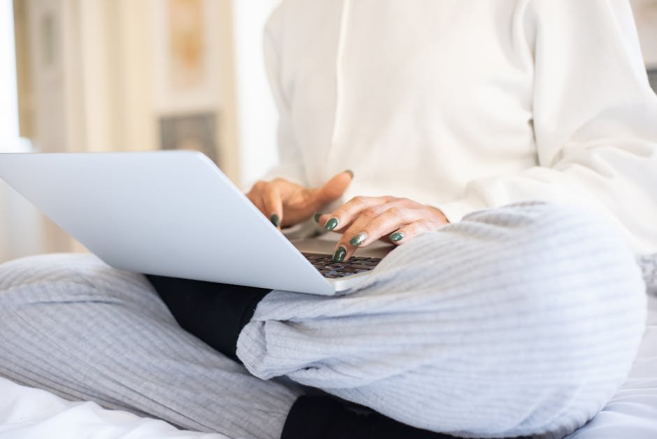 Close-up of a person using a laptop in a relaxed home setting in Portugal.