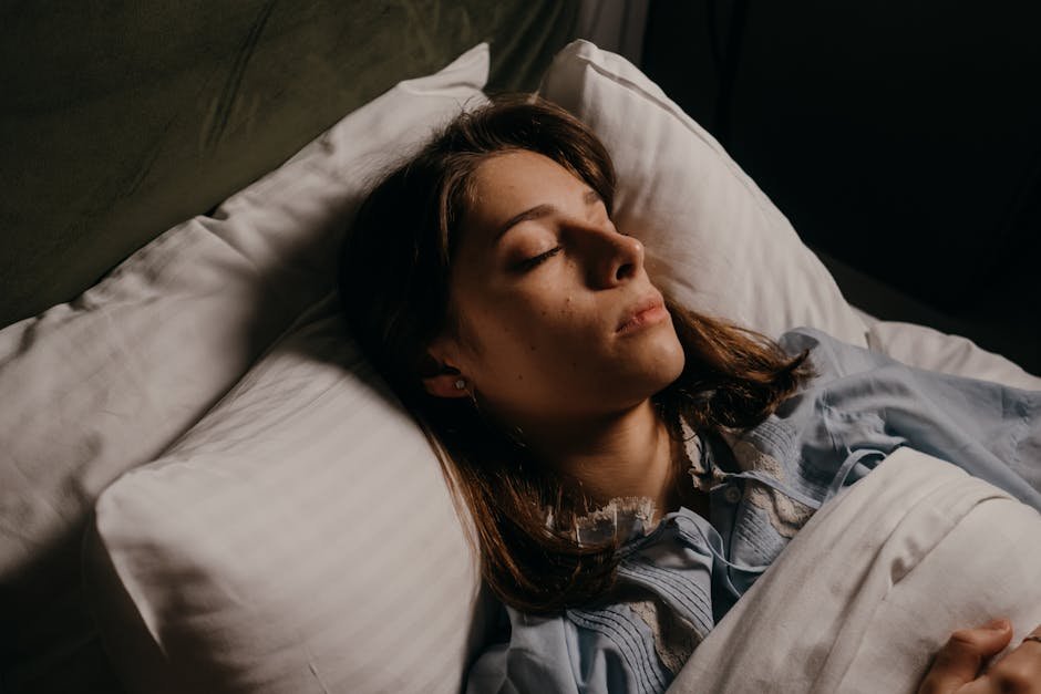 Woman sleeping peacefully in bed, highlighting comfort and serenity in a cozy bedroom setting.