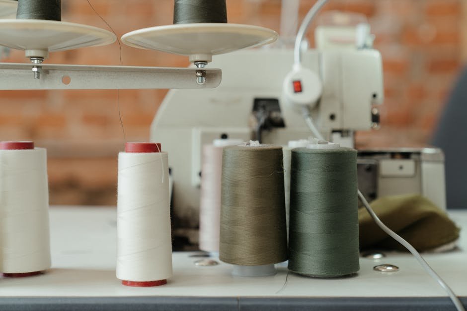 Sewing machine and colorful thread spools in detail, showcasing a creative workspace.