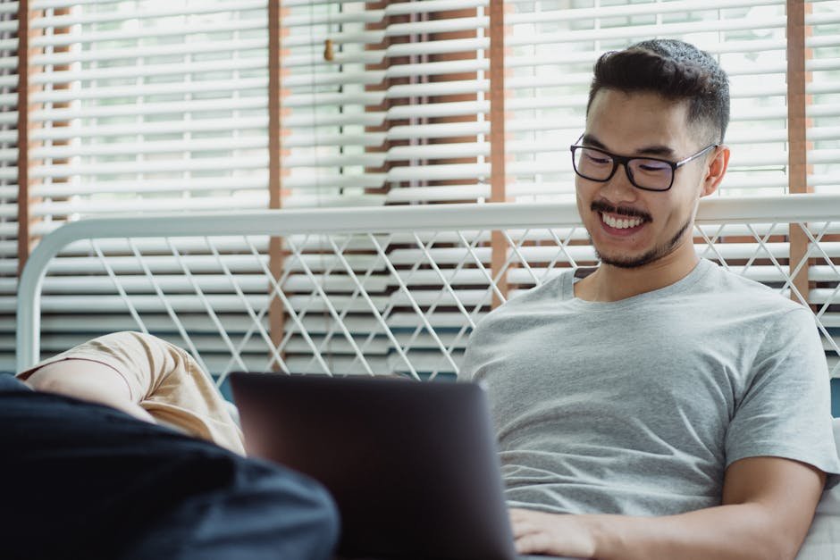 Man enjoying a relaxed moment using a laptop in a cozy indoor setting.